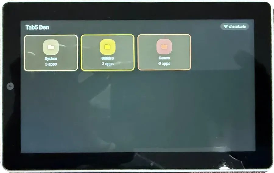The Tab5 device showing the Tab5 Den launcher: three folder tiles reading System 3 apps, Utilities 3 apps and Games 6 apps.